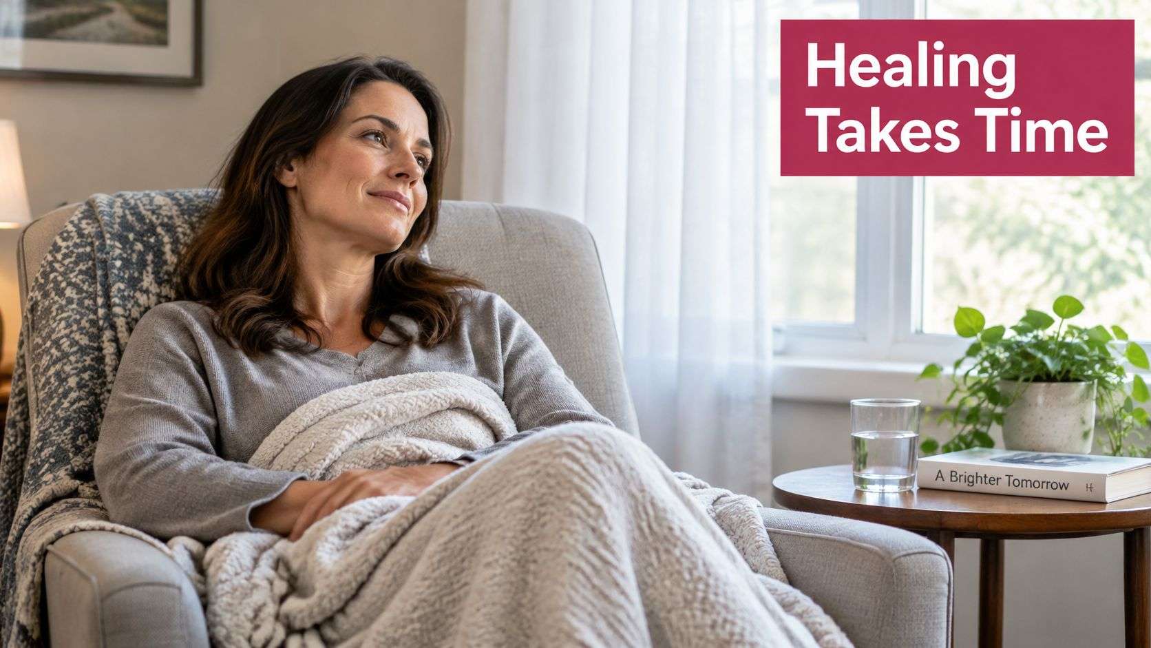 A woman resting comfortably under a blanket in a chair, reflecting on her healing journey.