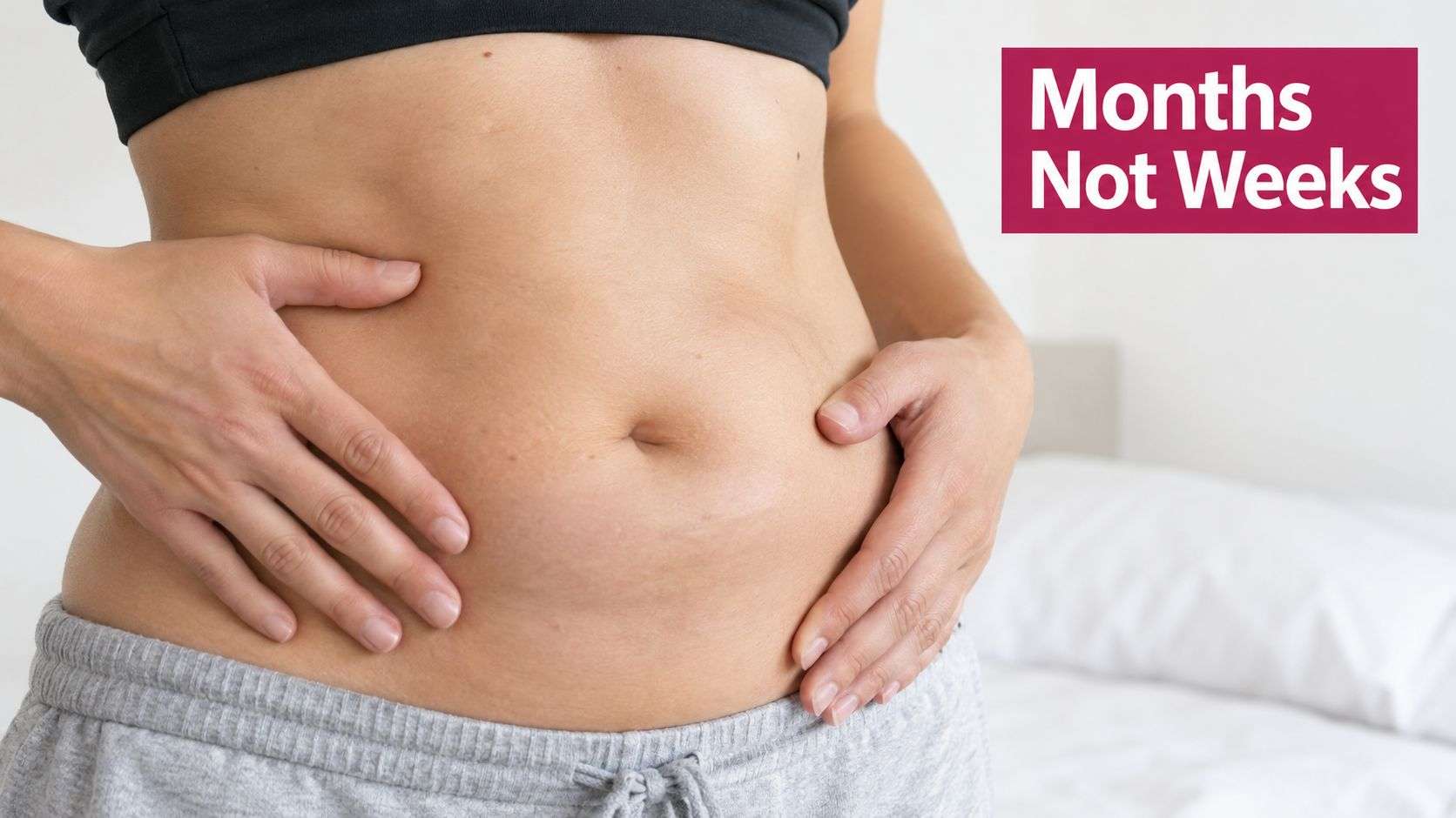 A person with their hands on their stomach, representing recovery or body transformation progress.